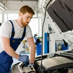 Mécanicien travaillant sur un moteur de Mercedes. Obtenez le meilleur prix vidange Mercedes pour l'entretien de votre véhicule.