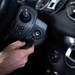 Main d'homme insérant une clé dans le Neiman d'une voiture. Le prix du changement de Neiman est une préoccupation courante.