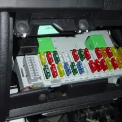 Boîte de fusibles de voiture avec des fusibles colorés de différentes ampérages. Un fusible de 20A est visible.