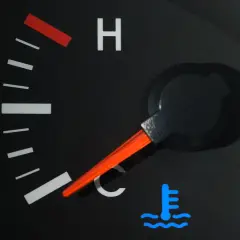Indicateur de température de voiture avec aiguille sur la zone bleue et symbole de thermomètre.