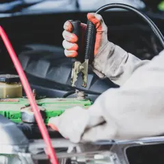 Mainteneur branchant des câbles sur la batterie pour démarrer une voiture qui ne démarre pas mais batterie ok.