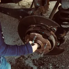 Un enfant touche le système de freinage d'une voiture. Un diagnostic freinage gratuit est peut-être en cours.