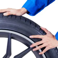 Mains inspectent un pneu, suggérant une inspection avant une réparation pneu mèche interdit.
