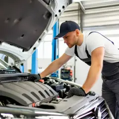 Mécanicien vérifiant le moteur d'une BMW Série 1. Il est temps de vérifier où mettre le liquide de refroidissement.