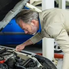 Mécanicien concentré sur le moteur, s'assurant de la pleine puissance moteur de la voiture.
