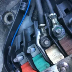 Boîtier de fusibles d'une Peugeot 207, incluant le fusible direction assistée. Connexions et câbles visibles.
