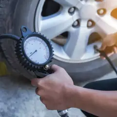 Contrôle de la pression pneu autoroute avec un manomètre. Assurer la sécurité avant le départ.