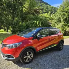 Renault Captur rouge garé dans un paysage verdoyant. Idéal pour connaître le prix révision Renault Captur 60000 km.