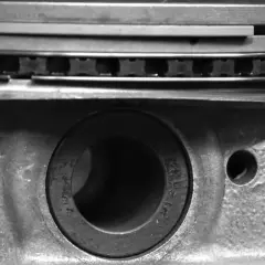 Gros plan sur un piston de moteur, montrant les segments et le logement de l'axe. La segmentation moteur est essentielle pour l'étanchéité.