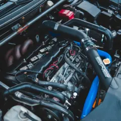 Moteur de voiture avec durites bleues et noires. Un symptôme capteur pression admission HS peut être lié à ces composants.