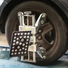 Réglage du parallélisme des roues d'une voiture avec un appareil de mesure. Le montage pneu et parallélisme est essentiel pour une conduite sûre.
