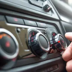 Main gauche sur le bouton de température, le chauffage de la voiture est réglé au maximum. Le liquide de refroidissement est peut-être bas.