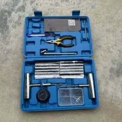 Kit de réparation pour pneu de voiture : mèches, pince, cutter, et outils pour une intervention rapide.