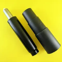 Pièce de rechange pour chaise de bureau : un poussoir hydraulique bloqué et son cache noir, prêts à être remplacés.