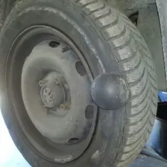 Gros plan sur une roue de voiture avec une hernie sur le pneu, signe d'un problème de sécurité.