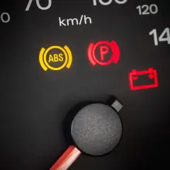 Voyant ABS allumé, un symptôme possible d'un capteur ABS défectueux. Le tableau de bord affiche aussi les voyants de frein de parking et de batterie.