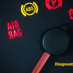 Tableau de bord d'une voiture avec le voyant "AIR BAG" allumé en rouge, signalant un problème. Le voyant ABS est jaune.