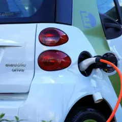 Une voiture électrique blanche est branchée. La question est : peut-on laisser charger une batterie de voiture toute la nuit ?