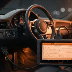 Diagnostic auto dans une voiture de luxe. L'appareil affiche des graphiques de performance moteur, utile pour connaître le prix valise voiture.