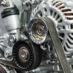 Détail d'un alternateur de voiture avec courroie et poulie damper. Le bruit de poulie damper peut indiquer un problème.