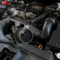 Main tenue un débitmètre d'air défectueux, un symptôme courant de problèmes moteur.