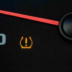 Voyant orange en forme de pneu avec un point d'exclamation, indiquant un problème de pression pneu.