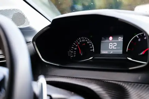 Tableau de bord d'une voiture affichant 82 km/h. Pour savoir si une voiture est gagée, vérifiez son historique.