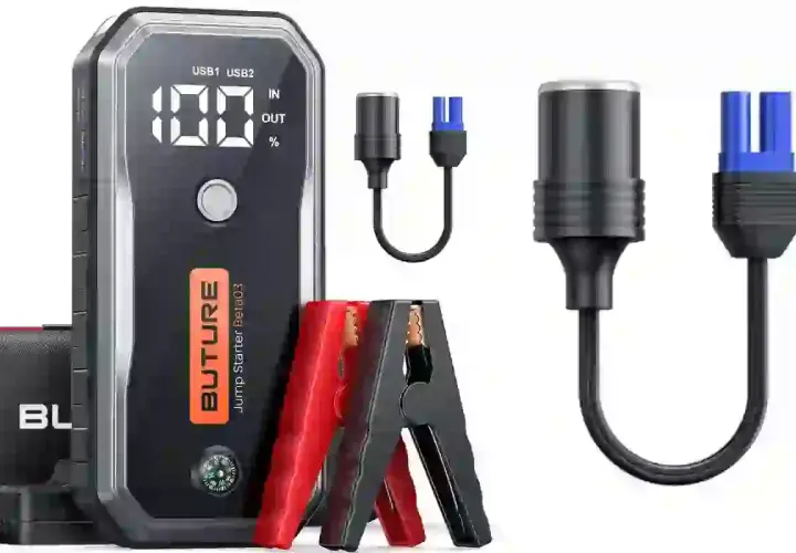 Boîtier noir avec écran affichant 100%, pinces rouges et noires, et câbles pour comment charger une batterie.