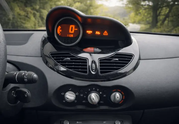 Tableau de bord d'une Twingo 2, prêt pour la vidange. Le compteur affiche 0 km/h, avec des voyants moteur et d'alerte allumés.