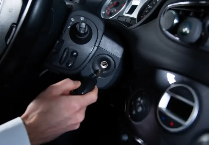 Main d'homme insérant une clé dans le Neiman d'une voiture. Le prix du changement de Neiman est une préoccupation courante.