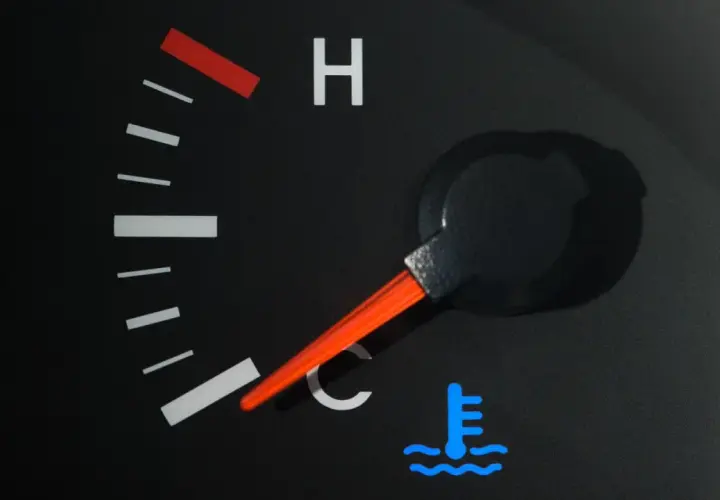 Indicateur de température de voiture avec aiguille sur la zone bleue et symbole de thermomètre.