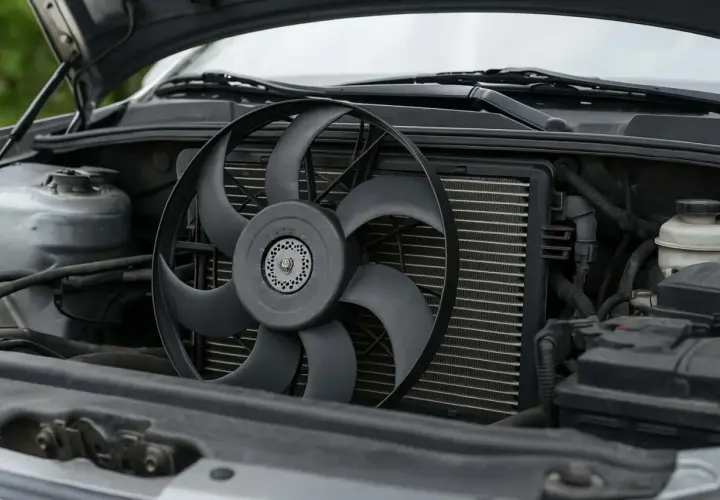 Le ventilateur de voiture est visible devant le radiateur, prêt à refroidir le moteur froid.