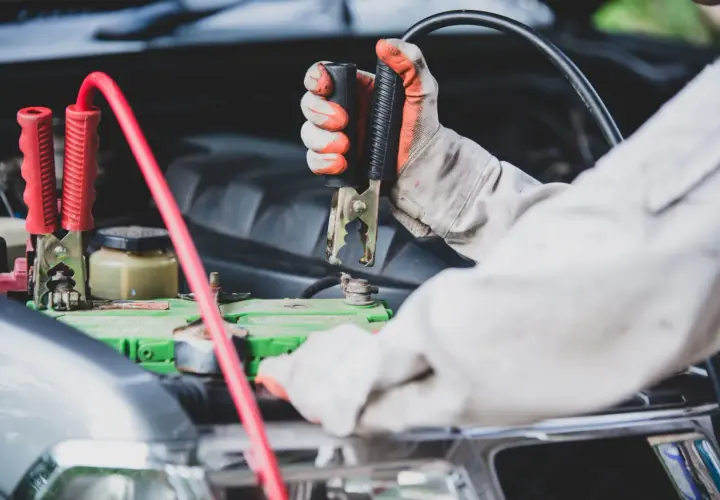 Mainteneur branchant des câbles sur la batterie pour démarrer une voiture qui ne démarre pas mais batterie ok.