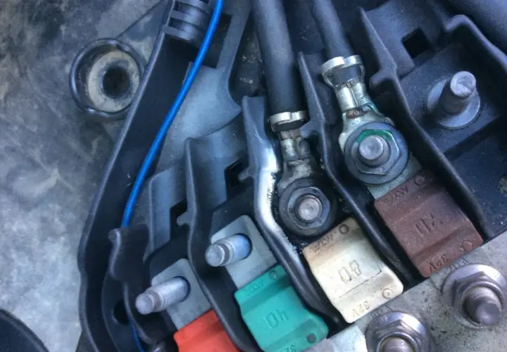 Boîtier de fusibles d'une Peugeot 207, incluant le fusible direction assistée. Connexions et câbles visibles.