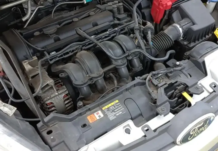 Moteur de Ford Fiesta essence. Le démarreur est caché sous le collecteur d'admission, près de l'alternateur.