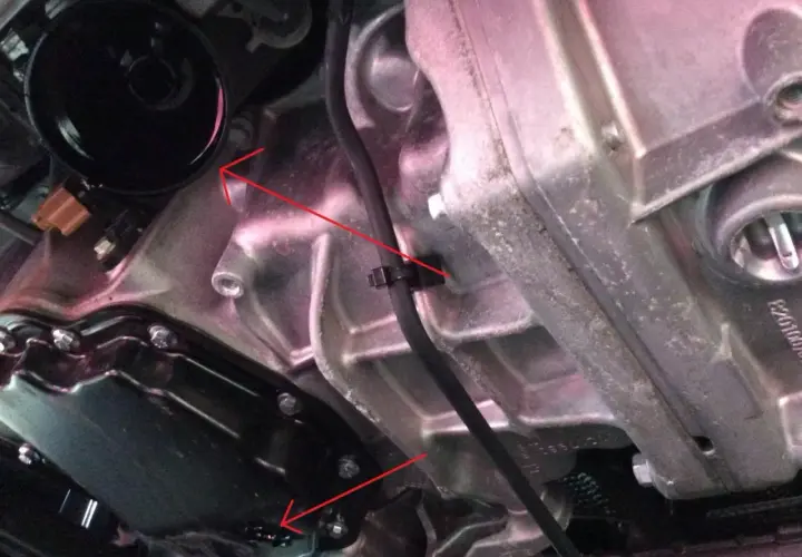 Vue détaillée du moteur d'une Scenic 3, montrant le carter d'huile et le filtre, lors d'une vidange.