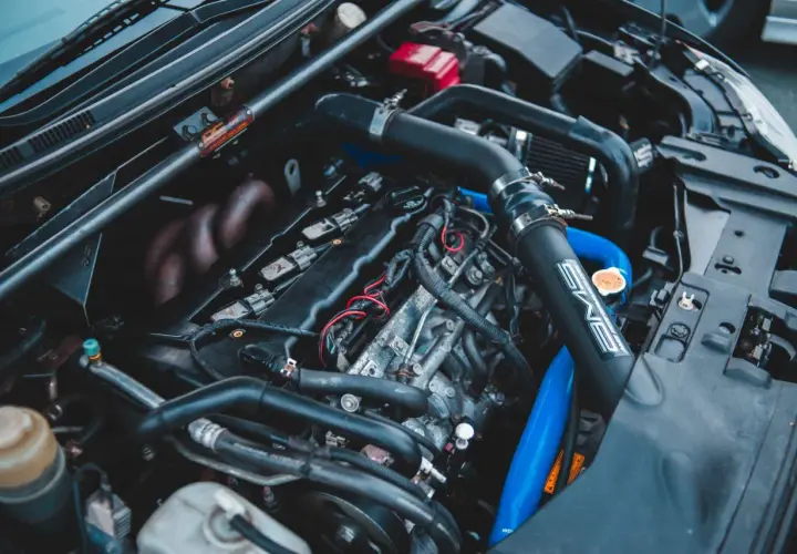 Moteur de voiture avec durites bleues et noires. Un symptôme capteur pression admission HS peut être lié à ces composants.