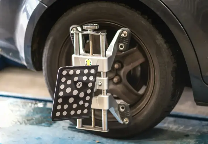 Réglage du parallélisme des roues d'une voiture avec un appareil de mesure. Le montage pneu et parallélisme est essentiel pour une conduite sûre.