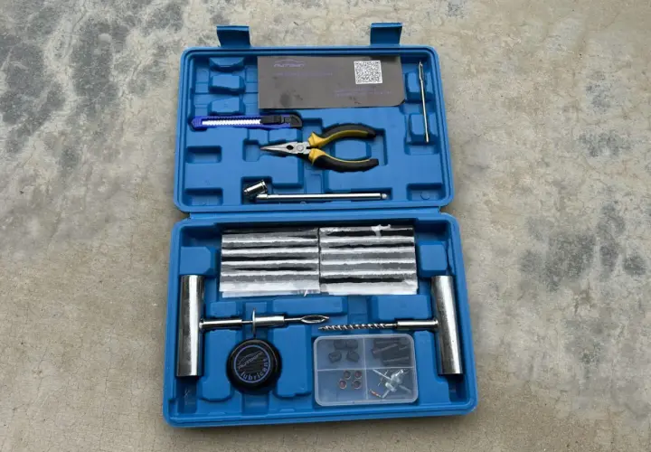 Kit de réparation pour pneu de voiture : mèches, pince, cutter, et outils pour une intervention rapide.