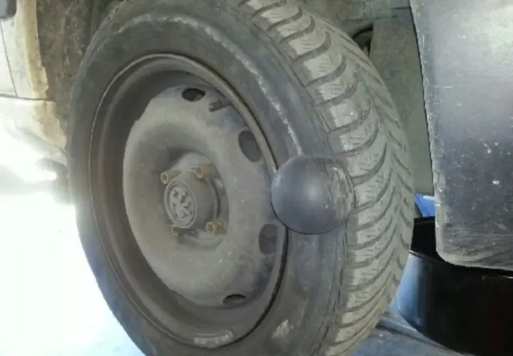 Gros plan sur une roue de voiture avec une hernie sur le pneu, signe d'un problème de sécurité.
