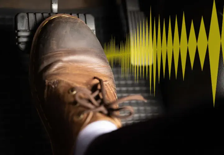 Un pied en chaussure marron appuie sur la pédale de frein, symbolisant le bruit frottement freinage.