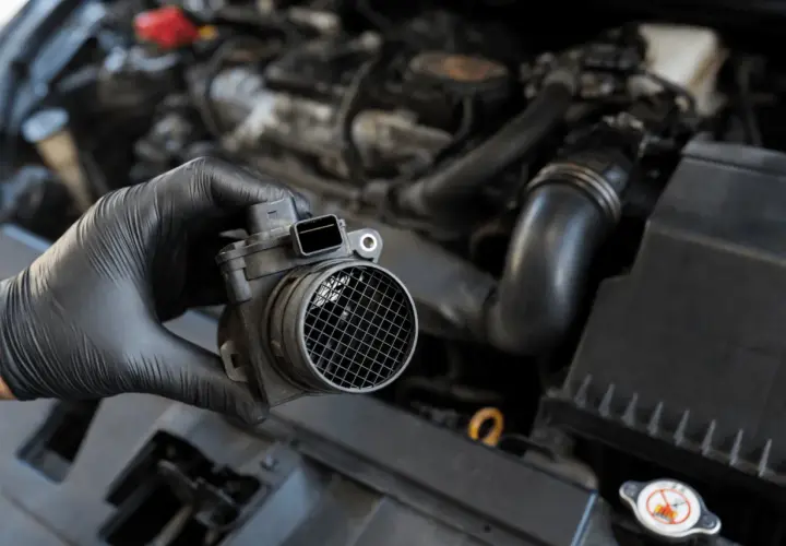 Main tenue un débitmètre d'air défectueux, un symptôme courant de problèmes moteur.
