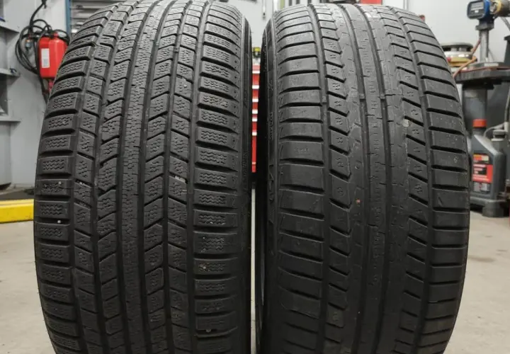 Deux pneus côte à côte : l'un avec un profil profond et lamellisé pour l'hiver, l'autre plus lisse. Apprenez à reconnaître pneu hiver et 4 saisons.
