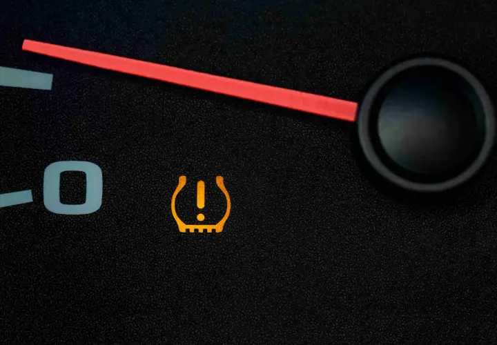 Voyant orange en forme de pneu avec un point d'exclamation, indiquant un problème de pression pneu.