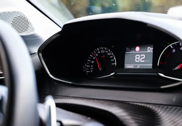 Tableau de bord d'une voiture affichant 82 km/h. Pour savoir si une voiture est gagée, vérifiez son historique.