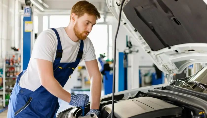 Mécanicien travaillant sur un moteur de Mercedes. Obtenez le meilleur prix vidange Mercedes pour l'entretien de votre véhicule.