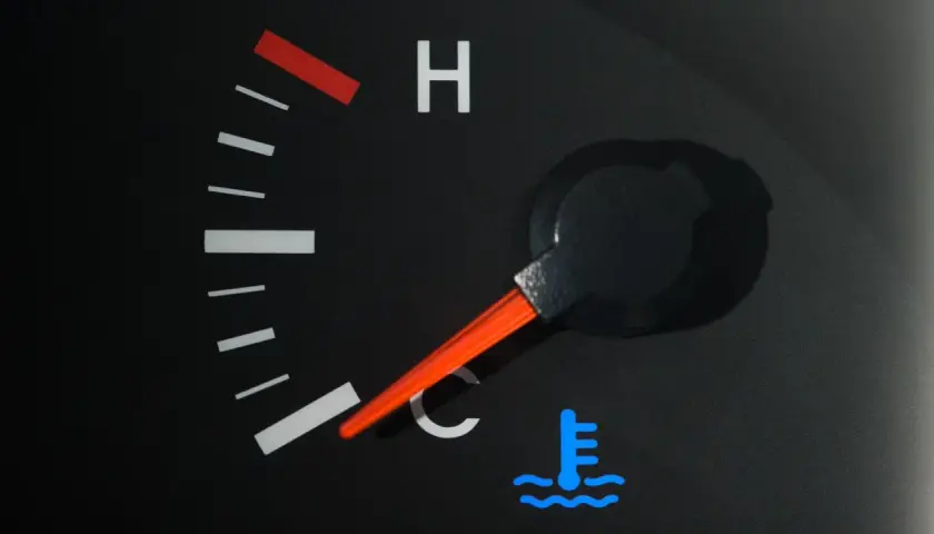 Indicateur de température de voiture avec aiguille sur la zone bleue et symbole de thermomètre.
