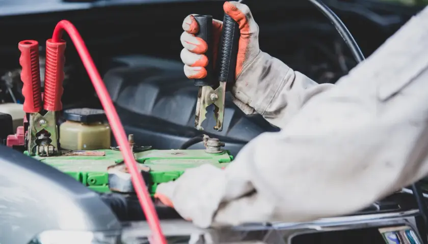 Mainteneur branchant des câbles sur la batterie pour démarrer une voiture qui ne démarre pas mais batterie ok.