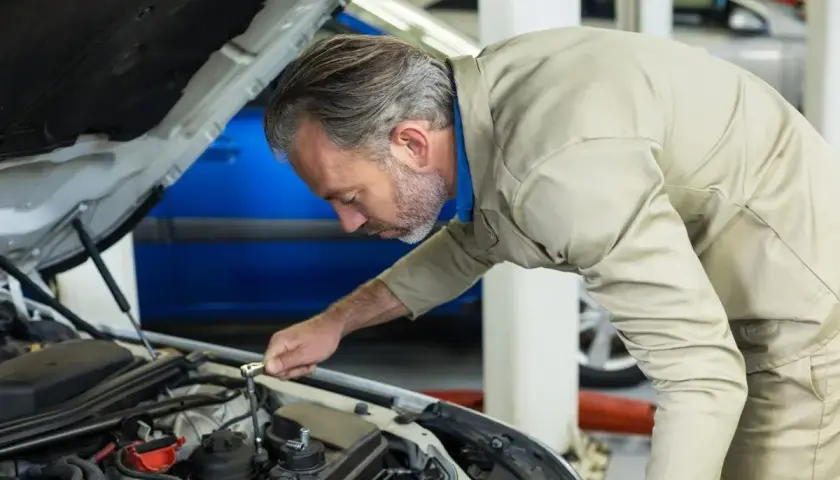 Mécanicien concentré sur le moteur, s'assurant de la pleine puissance moteur de la voiture.