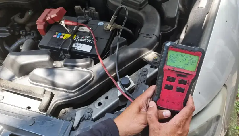 Test de batterie de voiture pour diagnostiquer une perte de puissance. L'appareil affiche un état de santé faible.